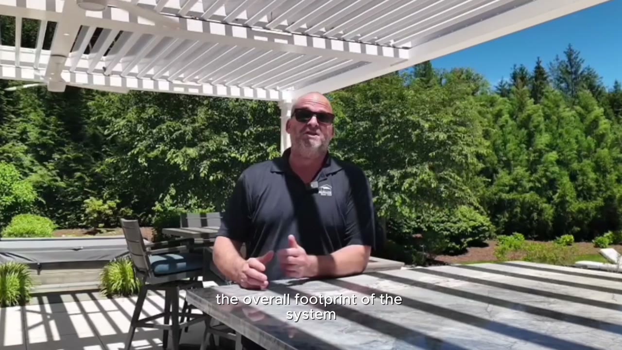 Dana Shaw explaining the Breslow process under a white motorized louvered pergola