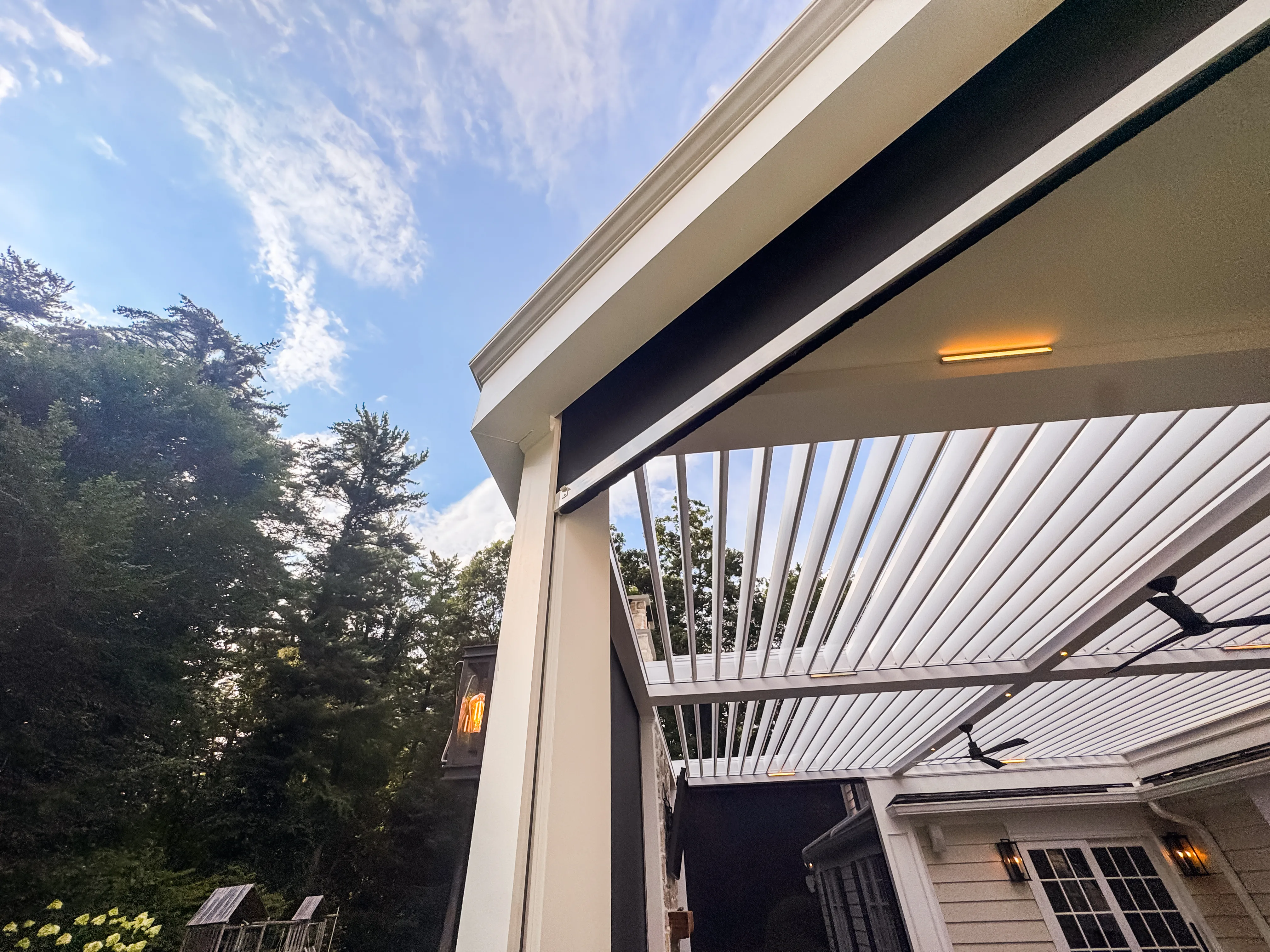 Motorized retractable screen concealed inside a custom pergola beam — Hambrook estate installation by Breslow