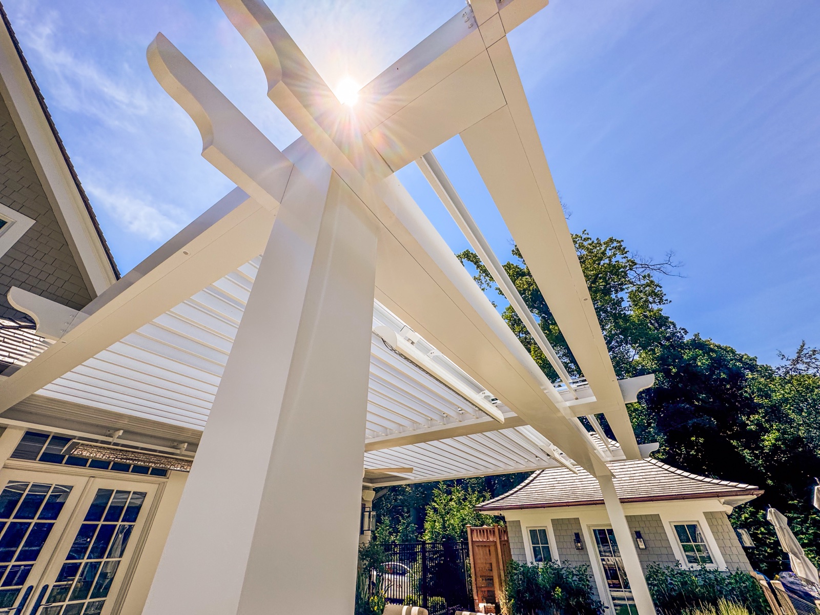 Detail of the custom decorative bracket and column trim on the louvered pergola