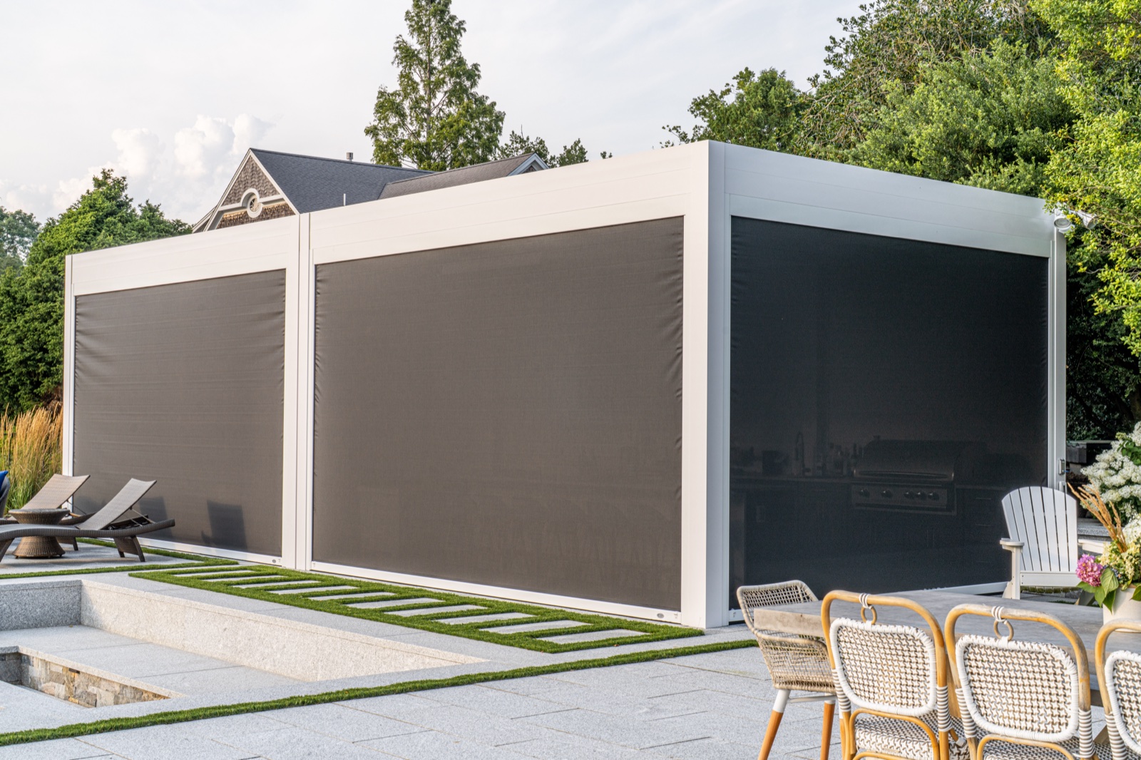 Motorized louvered pergola with privacy screens lowered beside the pool