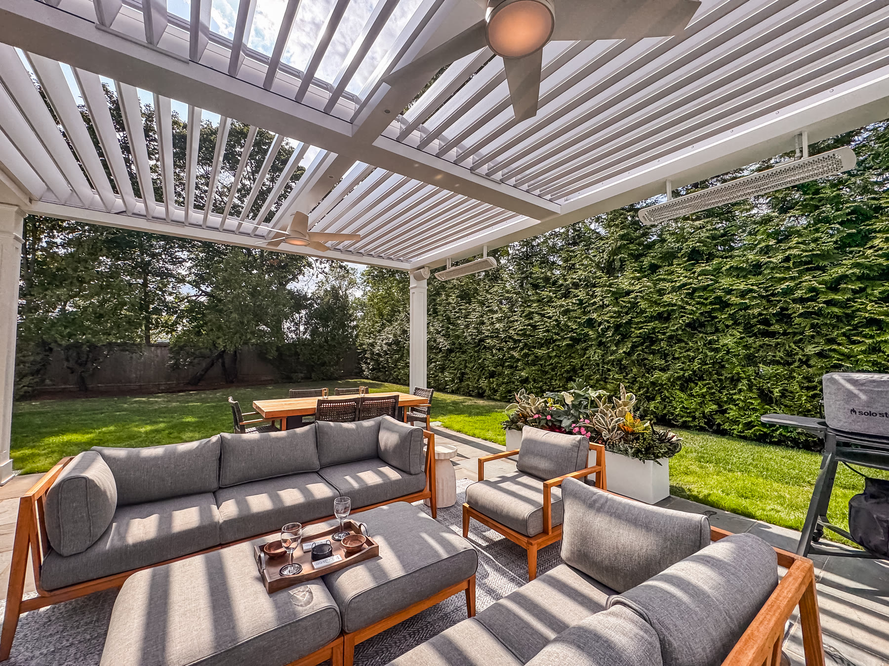 Custom louvered roof outdoor living room with Azek-wrapped columns in New Canaan, CT