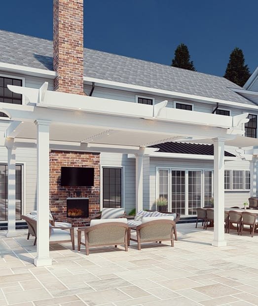 Stylish outdoor patio with a pergola, stone chimney, seating area, and a TV, surrounded by a modern home against a clear blue sky.